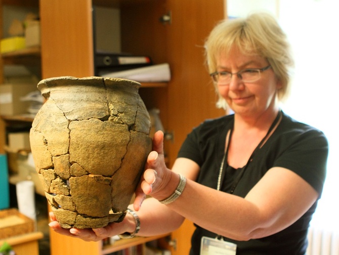 Anna Tyniec prezentuje średniowieczne naczynie znalezione w grobie