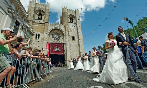  12.06.2012. Lizbona. Portugalia. Młodzi małżonkowie opuszczają katedrę.  Częścią obchodów ku czci św. Antoniego, urodzonego w Lizbonie patrona małżonków,  są śluby wielu par jednocześnie. W tym roku w związek małżeński wstąpiło ich 16.