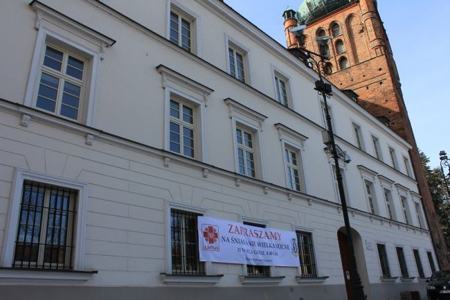 Baner na budynku płockiego opactwa z zaproszeniem na wielkanocne śniadanie