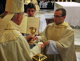 Abp Henryk Hoser symbolicznie przekazał na ręce nowych kapłanów wino w kielichu i chleb przygotowany do Mszy św.