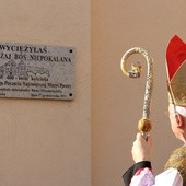 Bp Andrzej F. Dziuba przed pamiątkową tablicą