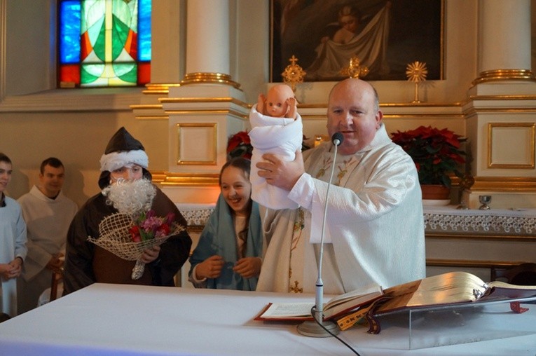 Ks. Grzegorz Gołąb i kolędnicy misyjni przy ołtarzu