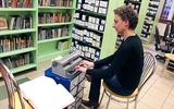   Małgorzata Arendarczyk za pomocą brajlowskiej maszyny do pisania pokazuje pismo oparte na sześciopunkcie
