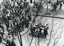 Gdynia, 17 grudnia 1970. Ulicą Świętojańską w kierunku centrum przechodzi pochód, demonstranci niosą na drzwiach zwłoki Zbigniewa Godlewskiego, który zginął w okolicy przystanku Gdynia -Stocznia, przeszyty serią z karabinu maszynowego