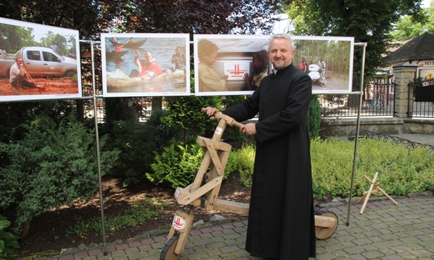 Ks. Jerzy Kraśnicki demonstruje przywieziony z misji w Afryce pojazd: rower z drewna