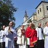 Procesja z relikwiami Drzewa Krzyża Świętego. W tle odbudowana  wieża kościelna