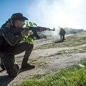 Uczestnicy manewrów obrony terytorialnej ćwiczą obronę  trasy konwoju w terenie 