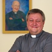  Ks. Adam Wodarczyk przed portretem ks. Franciszka Blachnickiego.  Biskup nominat jest autorem naukowej biografii założyciela  Ruchu Światło–Życie pt. „Prorok żywego Kościoła”