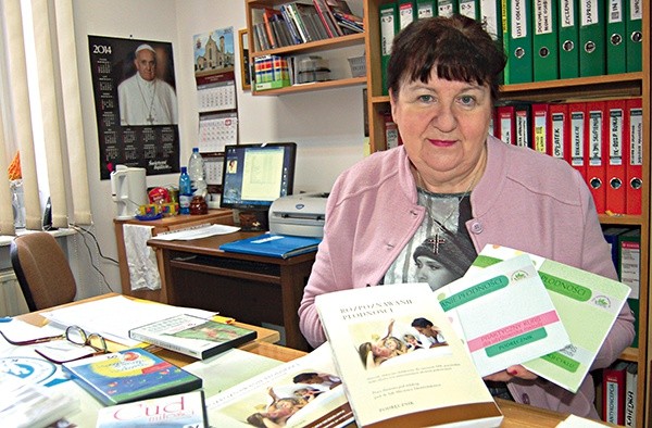  Małgorzata Górka pokazuje książki, które można wypożyczyć w ich ośrodku