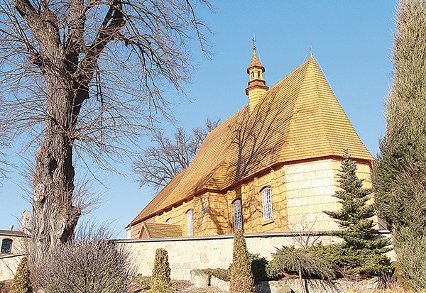 Nowiutki gont na dachu i ścianach jodłowskiej świątyni lśni w świetle słońca 