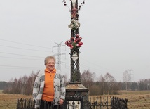 Elżbieta Sychowska pod krzyżem, który ufundowała rodzina z okazji I Komunii św. jednej z córek. Od tamtego czasu stał się miejscem wspólnej modlitwy w czasie okolicznościowych nabożeństw