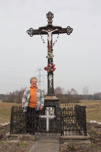 Elżbieta Sychowska pod krzyżem, który ufundowała rodzina z okazji I Komunii św. jednej z córek. Od tamtego czasu stał się miejscem wspólnej modlitwy w czasie okolicznościowych nabożeństw