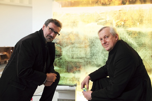 Proboszcz ks. Wojciech Chistowski wraz z Mariuszem Drapikowskim  przy panelu z całunem jeszcze przed jego montażem