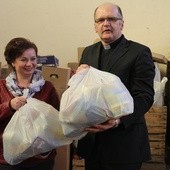 Ks. Grzegorz Wójcik i Iwona Stępniewska, pracownik Caritas, przy wydawaniem paczek