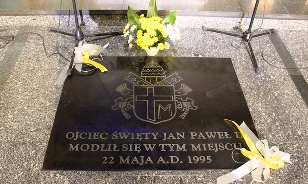 Wmurowana w podłogę kościoła NSPJ tablica informuje o obecności w nim Jana Pawła II