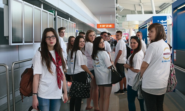  Młodzież w koszulkach promujących przyszłoroczne spotkanie  młodych na warszawskim Okęciu