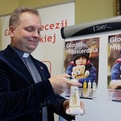 Do zapalenia świecy Caritas na wigilijnym stole zachęca ks. Robert Kowalski