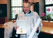 Józef Wloka ze złotym krzyżem w kształcie karo i potwierdzającym jego przyznanie dokumentem 