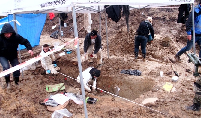 Prace przy odsłanianiu grobów pomordowanych partyzantów