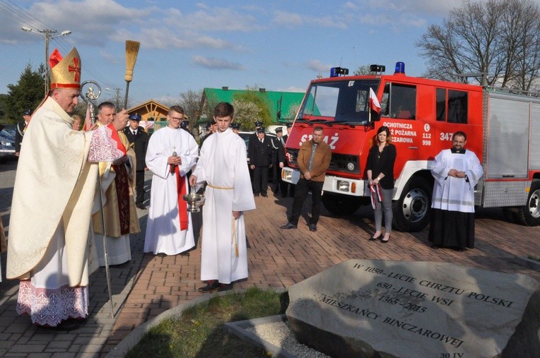 Bp Jeż błogosławi pamiątkowy kamień ufundowany z okazji jubileuszu wsi i 1050. rocznicy chrztu Polski. W tle nowy wóz strażacki miejscowej OSP