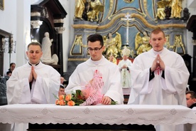 Nowo wyświęceni kapłani składają kwiaty na ołtarzu, jako wyraz wdzięczności Bogu za dar powołania