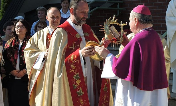 Ks. Maciej Zawisza SAC podaje bp. Tadeuszowi Rakoczemu relikiwie św. Jan Pawła II do uczczenia