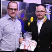Pan Jacek odbiera koszulkę Bartosza Kapustki, wygraną podczas licytacji. Z prawej ks. Jacek Miszczak, dyrektor radia RDN
