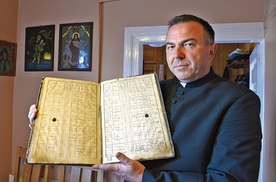▲	Proboszcz ks. Grzegorz Murawski prezentuje najstarszą zachowaną księgę parafialną z 1799 r.