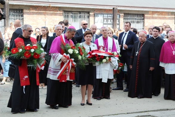 Bp Roman Pindel i premier Beata Szydło podczas złożenia kwiatów w miejscu placu apelowego, gdzie o. Kolbe zgłosił się na śmierć