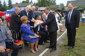 Włodarze gminy dzielili się chlebem z obecnymi na dożynkach. Z prawej wójt Marian Kmiecik