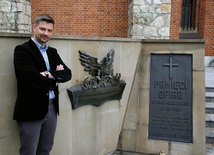 Dr hab. Filip Musiał przed tablicami „Pamięci ofiar stanu wojennego” oraz z okazji 25-lecia powstania „Solidarności”, które stoją przed bazyliką.