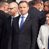 A. Duda i B. Szydło składają kwiaty pod bramą nr 2