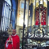 Proboszcz katedry błogosławi relikwiarzem z cząstką Drzewa Krzyża Świętego.