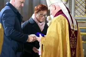 Biskup odbiera odznaczenie od władz województwa