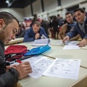 Uchodźca z Afganistanu wypełnia dokumenty  w biurze pracy w Berlinie. Państwo niemieckie coraz lepiej radzi sobie z opanowaniem fali uchodźców, społeczeństwo jednak nie ma już do rządzących zaufania.