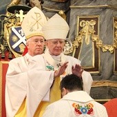 Abp Marek Jędraszewski nakłada dłonie na głowę bp. Wojciecha Osiala. Za nim bp Andrzej F. Dziuba