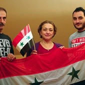 Od lewej: Nidal, Lena i Rafi w swoim opolskim mieszkaniu  z flagą Syrii.