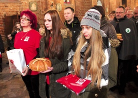 Osoby, które na co dzień pomagają potrzebującym, przyniosły w darach m.in. chleb, czapkę, szal i rękawiczki jako symbol pomocy niesionej osobom bezdomnym.