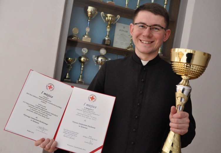 Dk Mateusz Kawa prezentuje puchar i dyplomy za zdobycie I miejsca w turnieju "Młoda krew ratuje życie".