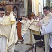 ▲	Zakładają stułę w poprzek ciała i wierzchnią szatę liturgiczną zwaną dalmatyką.