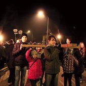 Młodzież i dzieci niosą krzyż podczas nabożeństwa ulicami dzielnicy Korabka w Łowiczu.