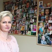 ▲	Elżbieta Stolarczyk, a w tle zdjęcia dzieci, którym udało się pomóc.