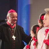 Biskup senior z młodymi wykonawcami koncertu.