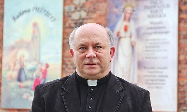 Ks. Krzysztof Fulek przed kościołem w Leszczynach