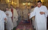 Bp Józef Zawitkowski niesie Najświętszy Sakrament po dywanie z kwiatów w kościele oo. pasjonistów w Rawie Mazowieckiej