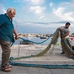 Stary Miguele razem z wnukiem naprawia sieć przed wypłynięciem na połów. Zawód rybaka przechodzi z ojca na syna.