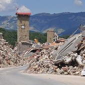 Symbol trzęsienia ziemi – kościelna wieża z zatrzymanym zegarem przypominającym o tragedii sprzed roku