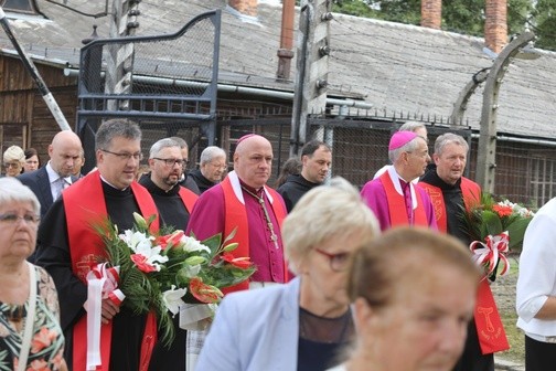 Procesja przekracza bramę obozową