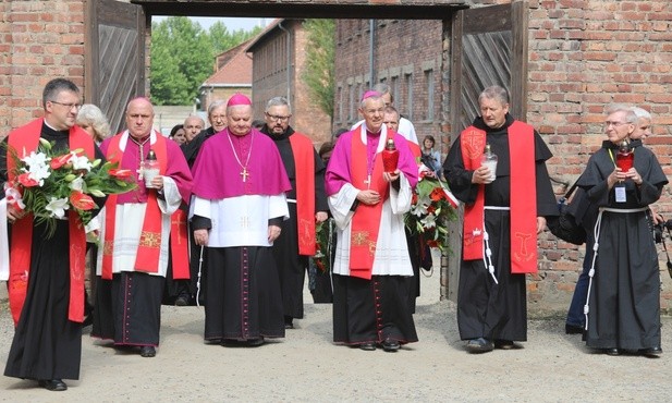 Biskupi i franciszkańscy współbracia św. Maksymiliana podchodzą do Ściany Śmierci obok bloku 11.