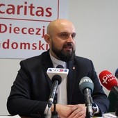 Ks. Damian Drabikowski podczas konferencji prasowej w siedzibie Caritas